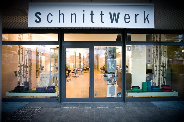 Moderner Friseursalon Schnittwerk mit Glasfront und einladender, heller Inneneinrichtung.