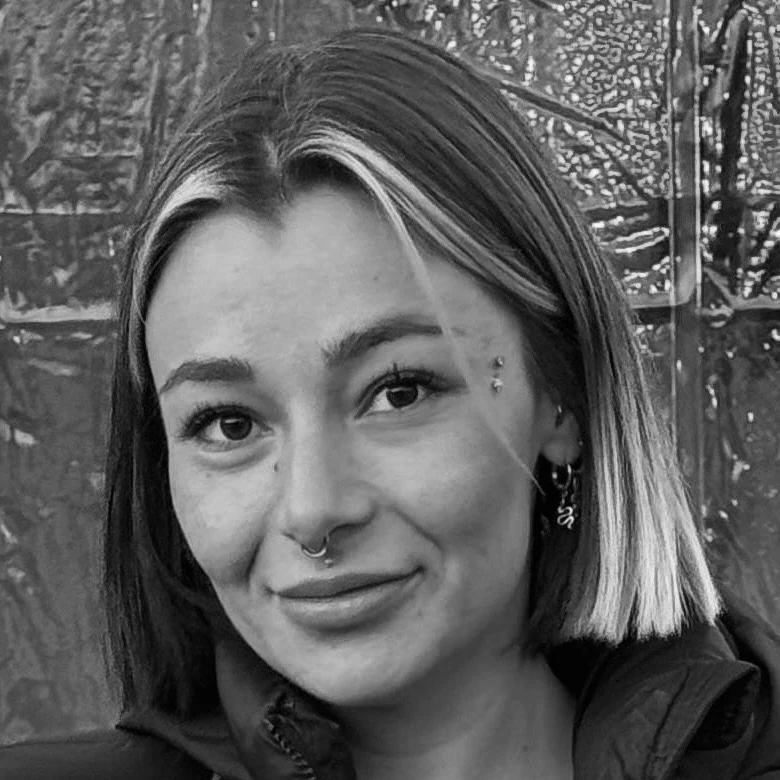 Porträt einer lächelnden Frau mit Piercings, Schwarzweiß-Foto im Freien